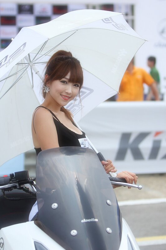 Woman with umbrella at motorcycle event