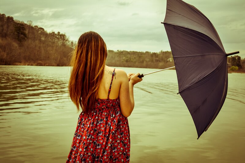 woman with umbrella by lake