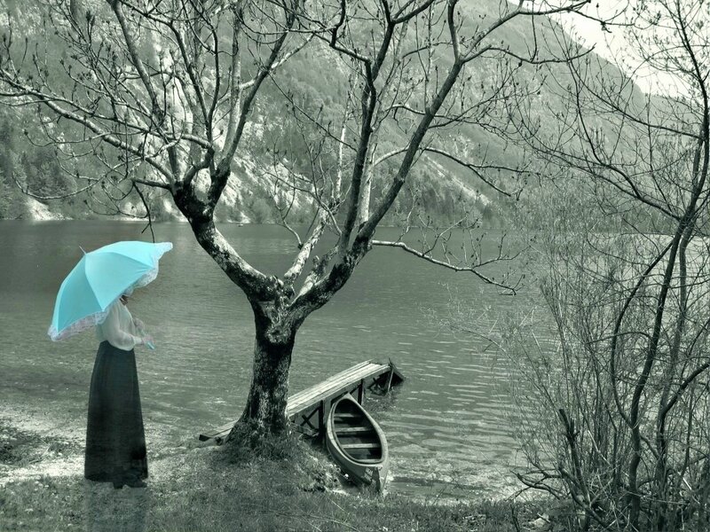 Woman with umbrella by lake