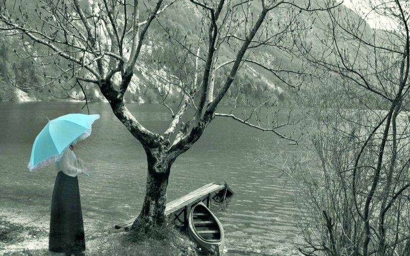woman with umbrella by lake