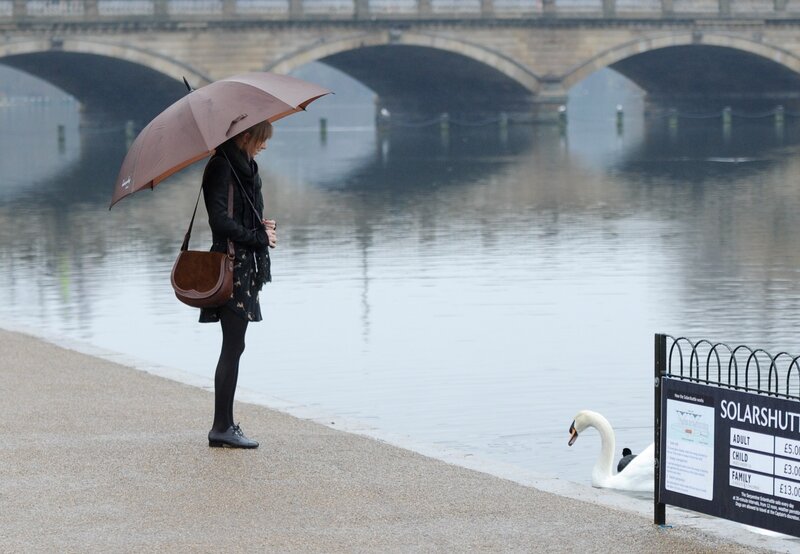 Woman with umbrella by river