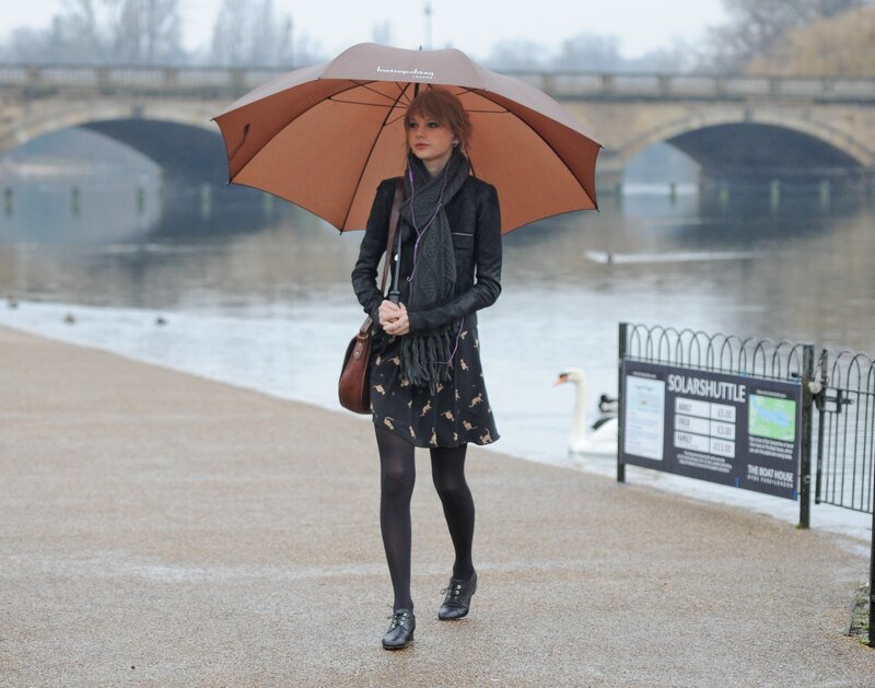 Woman with umbrella by river
