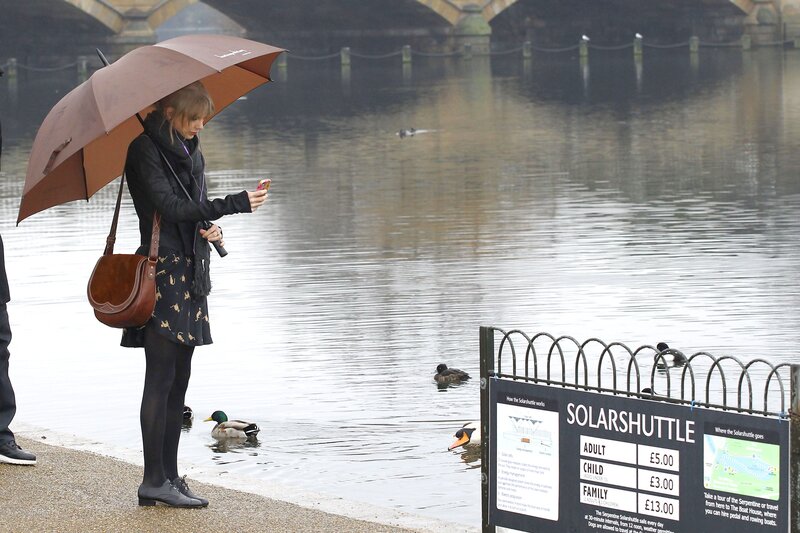 Woman with umbrella by river
