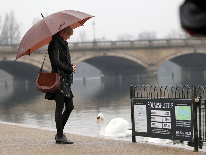 Woman with umbrella by river