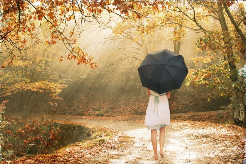 Woman with umbrella in autumn forest