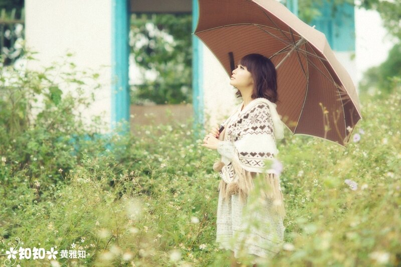 Woman with umbrella in field