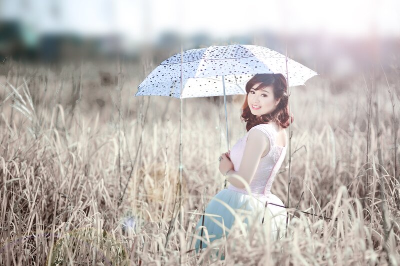 Woman with umbrella in field