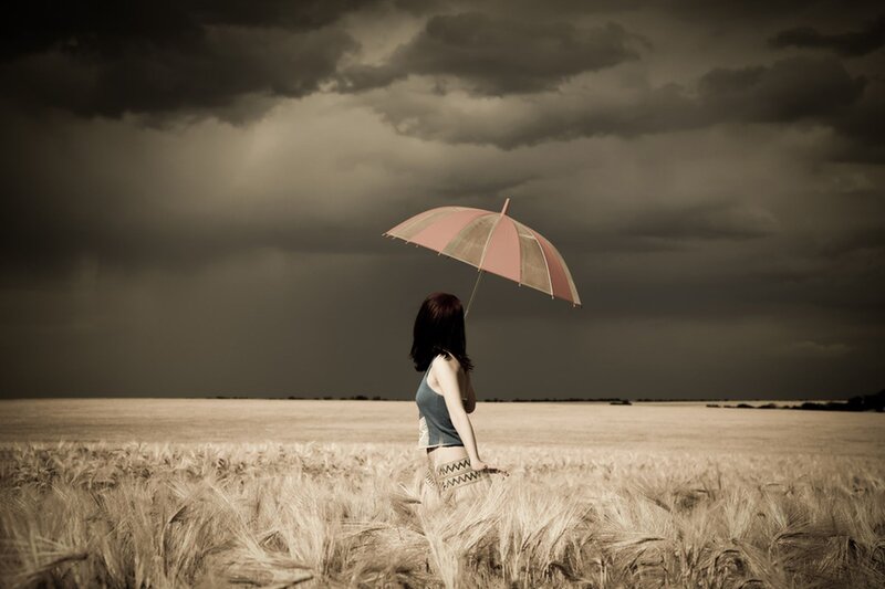 Woman with umbrella in field