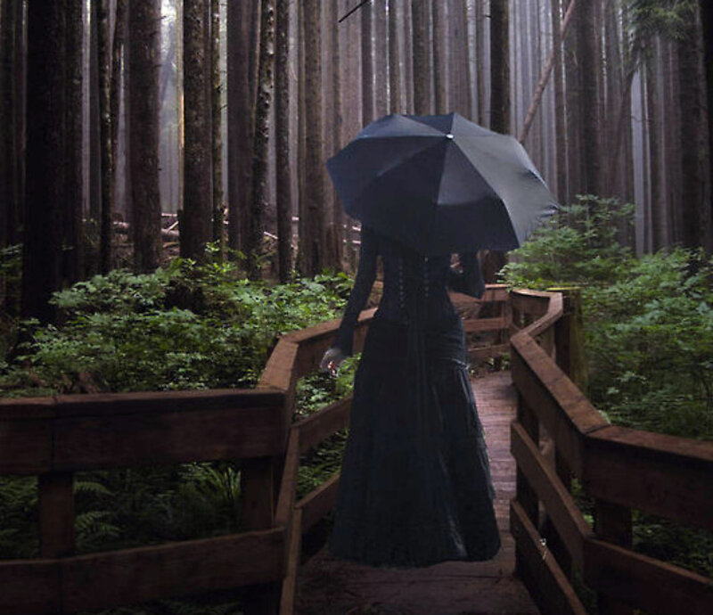 Woman with umbrella in forest