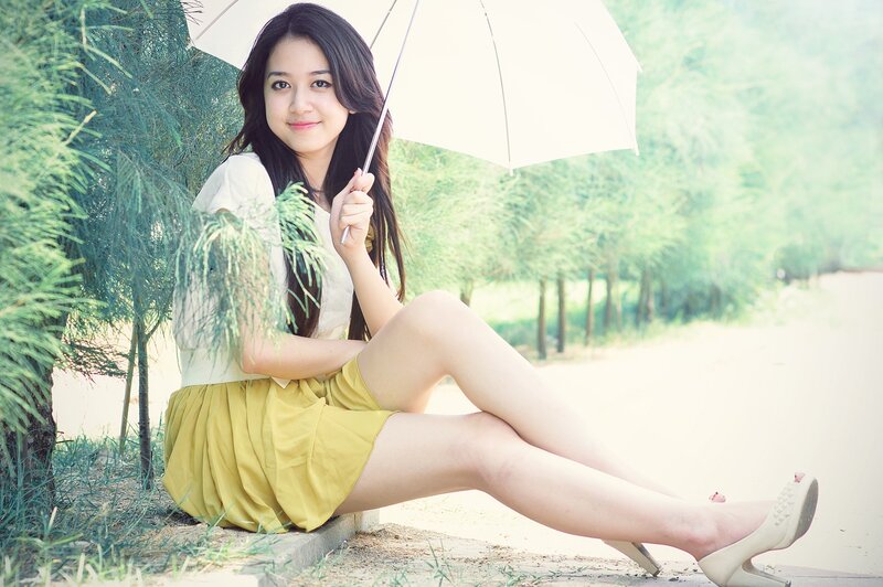Woman with umbrella in garden