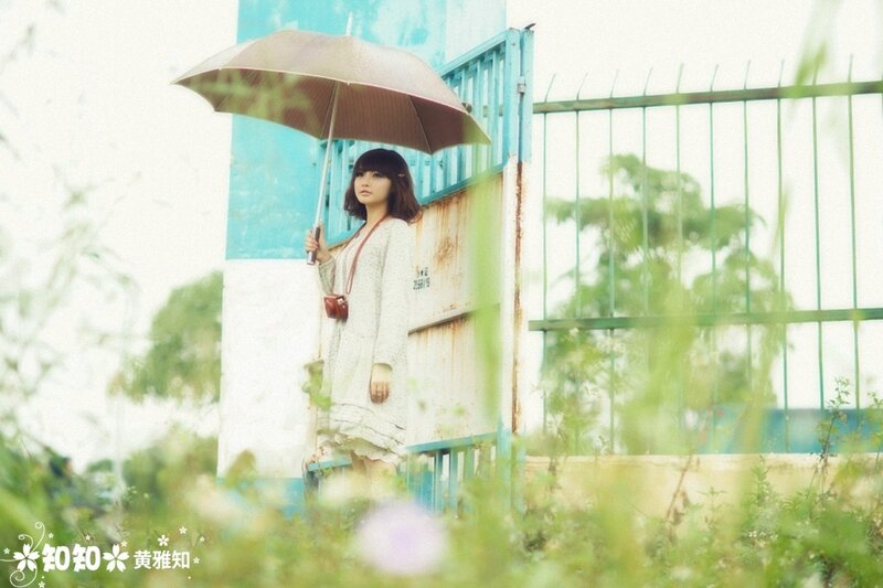 Woman with umbrella in overgrown area