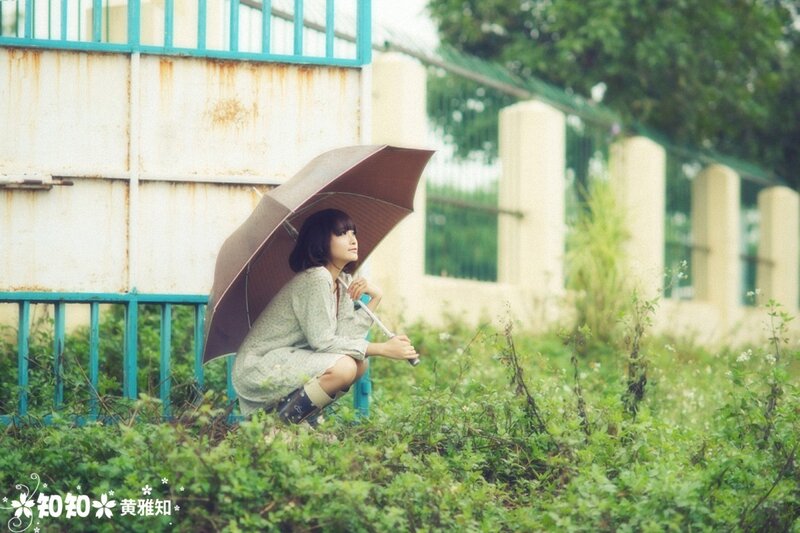 Woman with umbrella in overgrown area