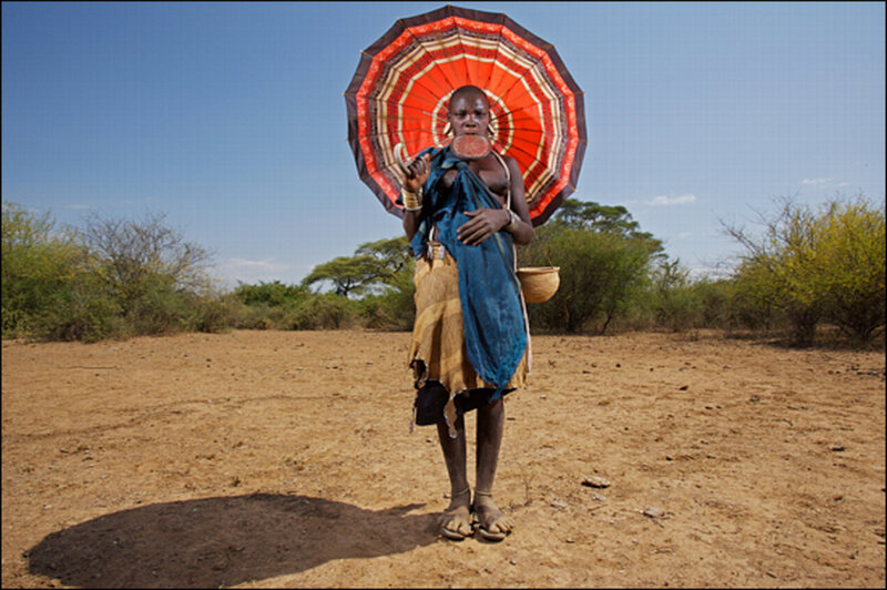 Woman with umbrella in savanna