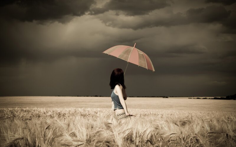 Woman with umbrella in wheat field