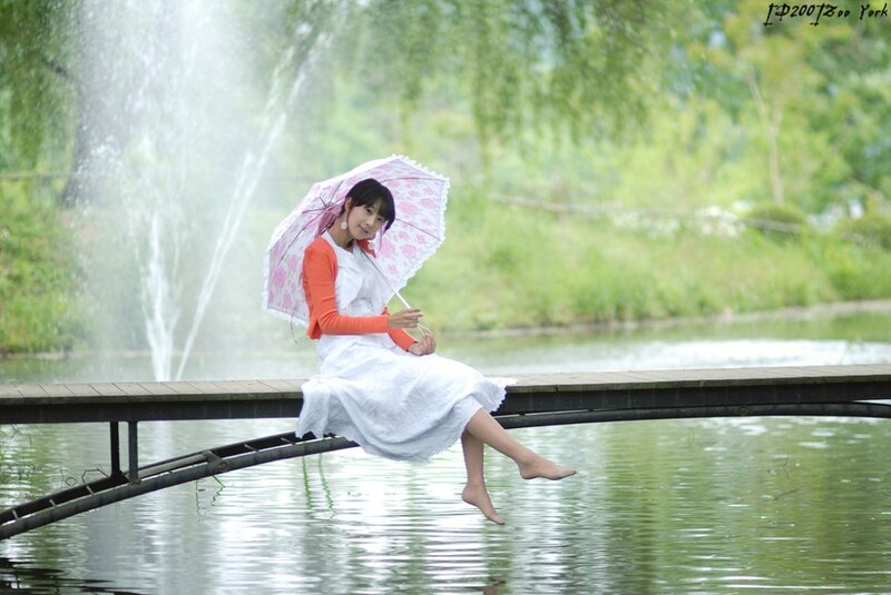 Woman with umbrella on bridge