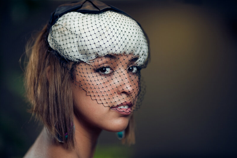 woman with veil and feather hat