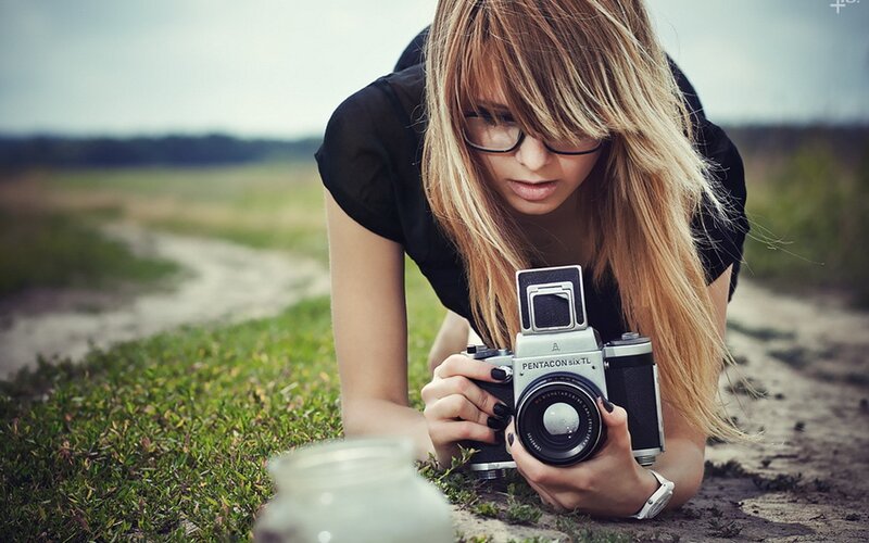 woman with vintage camera in field