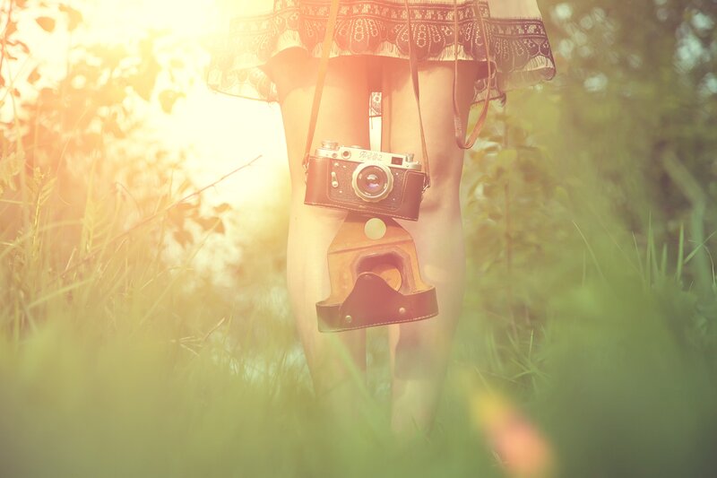 woman with vintage camera in field