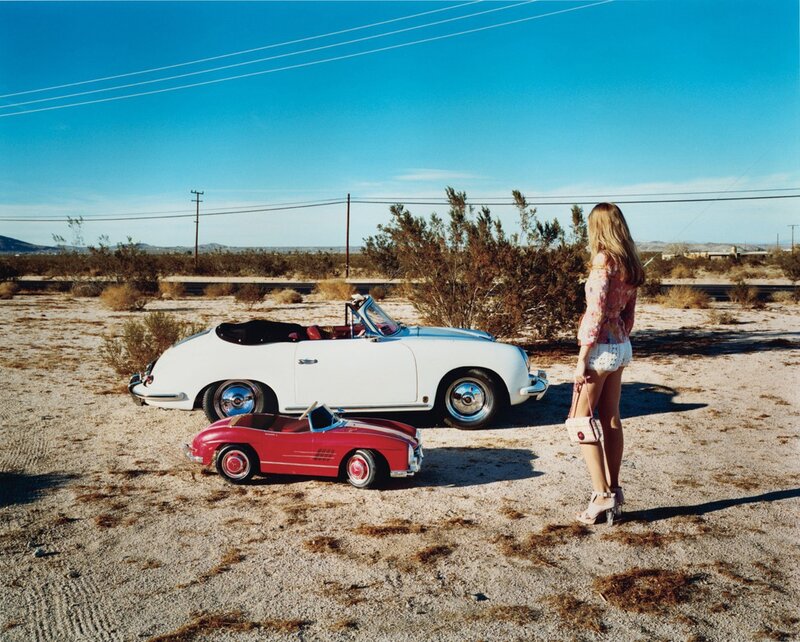 Woman with vintage cars in desert