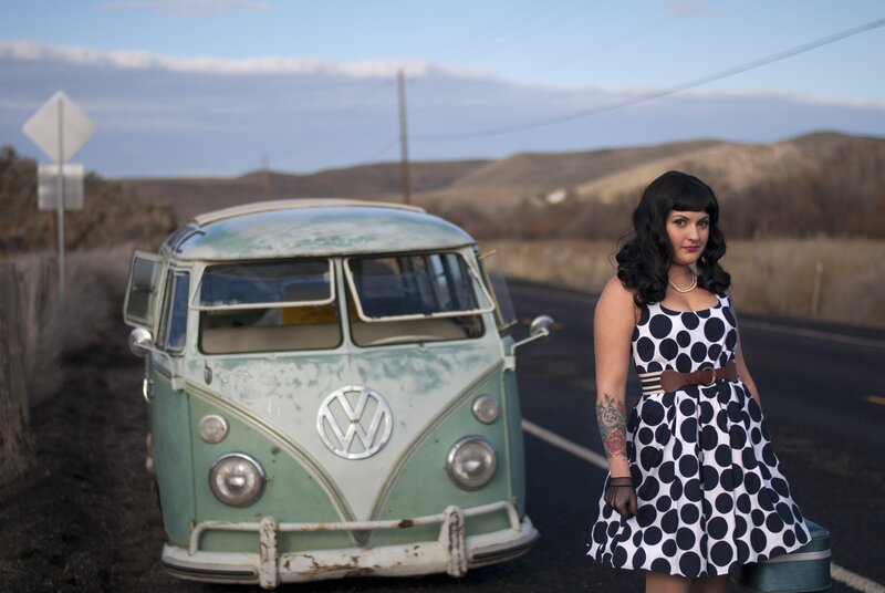 Woman with vintage van on road