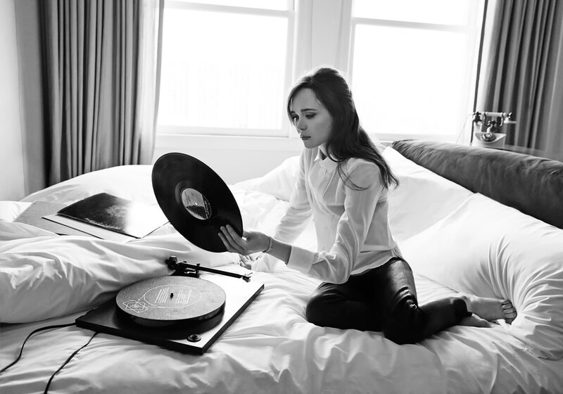 woman with vinyl record on bed