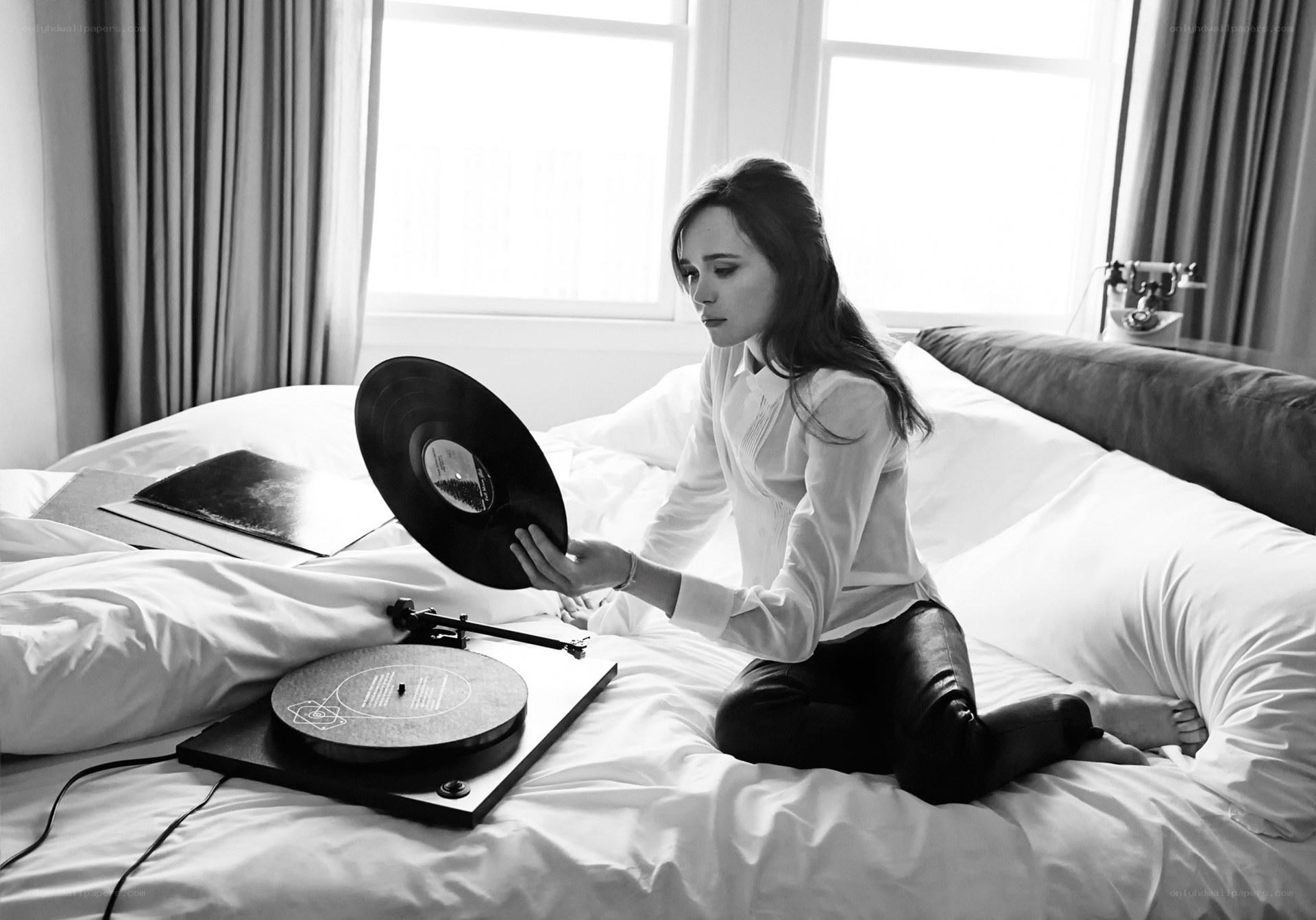 woman with vinyl record on bed