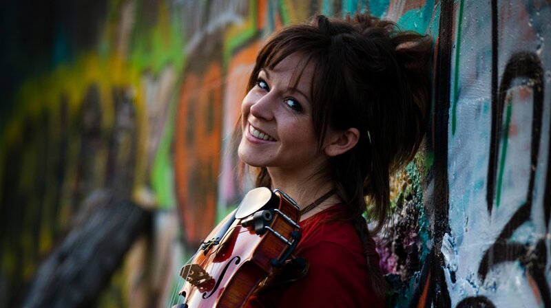 woman with violin against graffiti wall