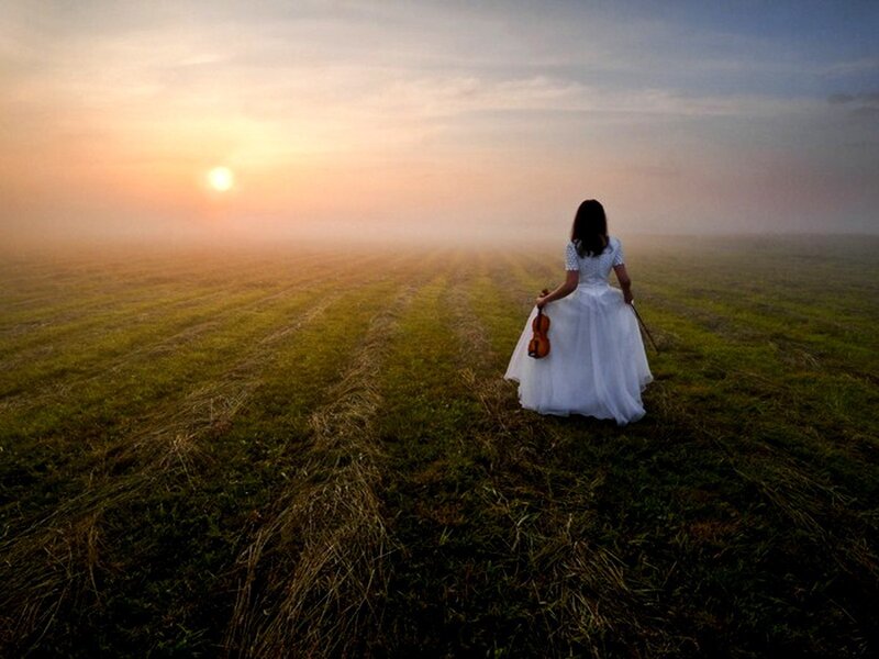Woman with violin in field