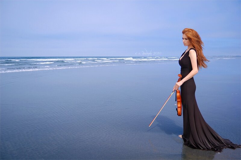 Woman with violin on beach