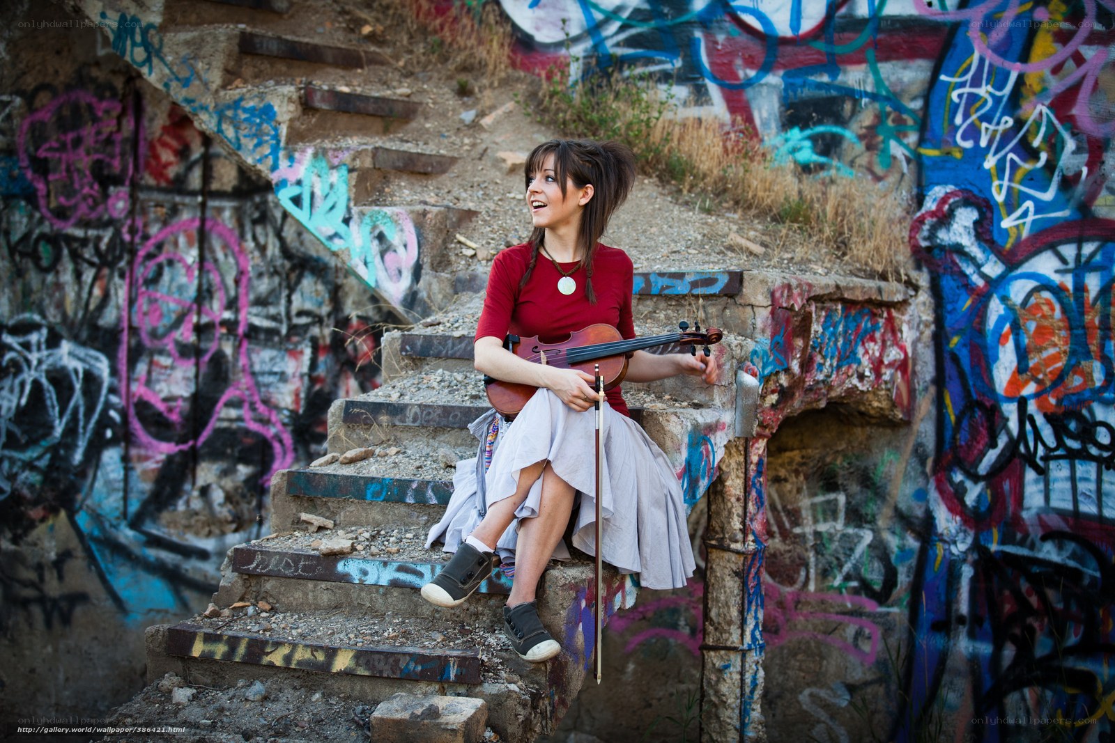 Woman with violin on graffiti stairs