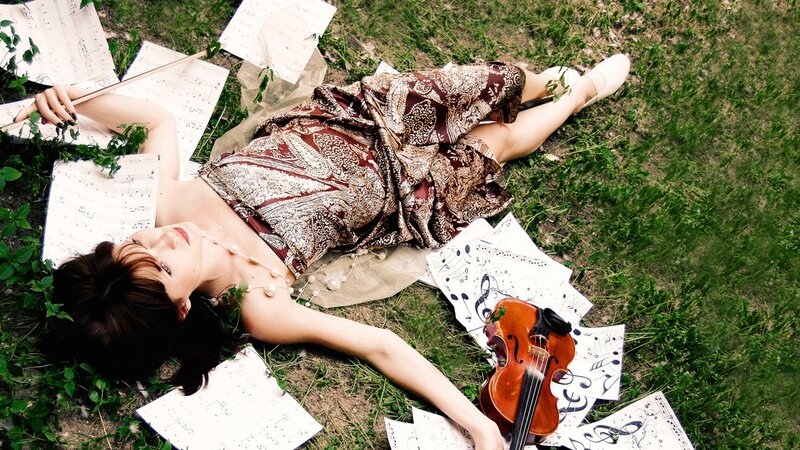 Woman with violin on grass