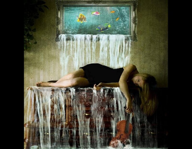 woman with violin under waterfall