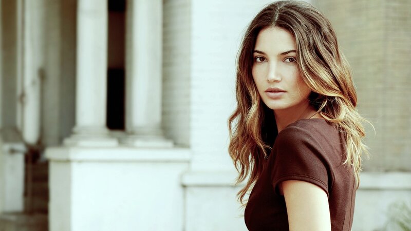 woman with wavy hair in brown shirt