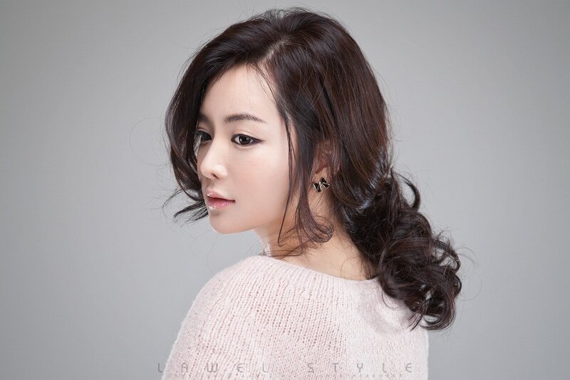 woman with wavy hair in pink sweater