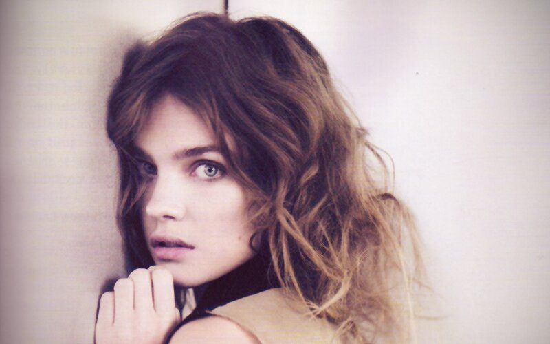 woman with wavy hair looking at camera