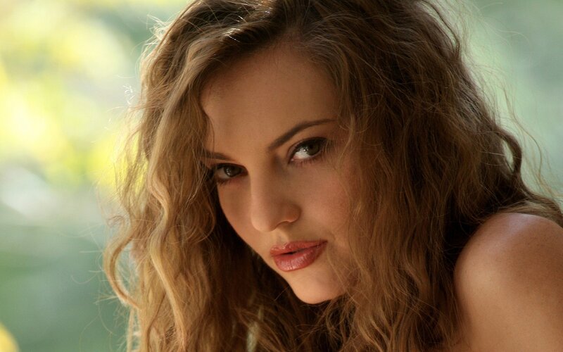 woman with wavy hair looking at camera