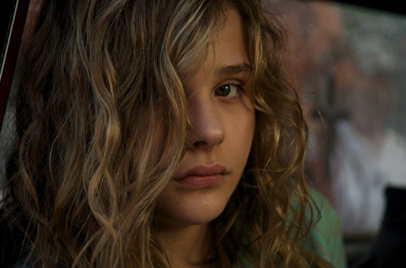 woman with wavy hair looking at camera