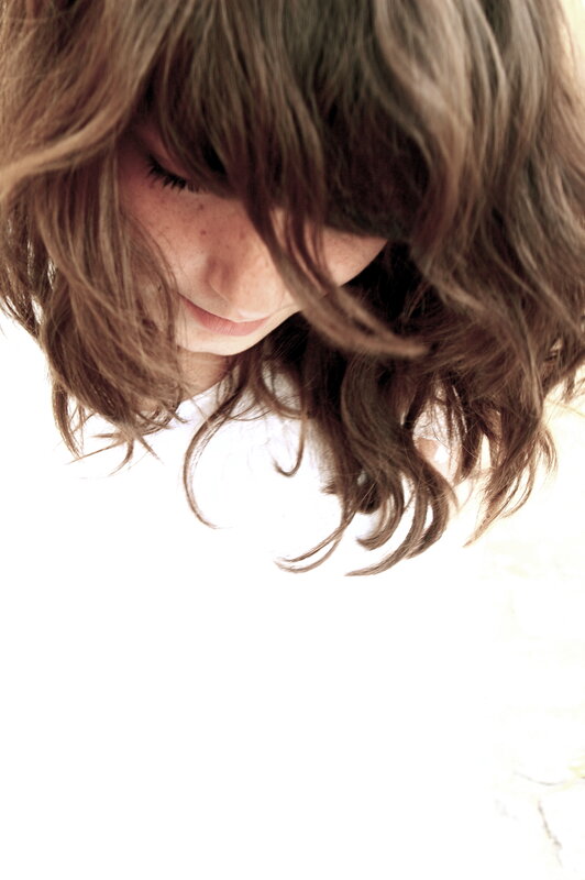 woman with wavy hair looking down