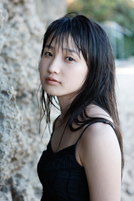 woman with wet hair by rock