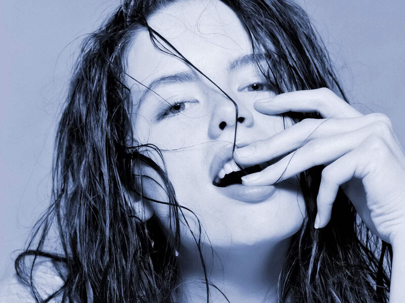 woman with wet hair covering mouth