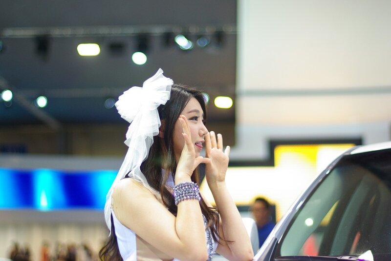 Woman with white bow at auto show