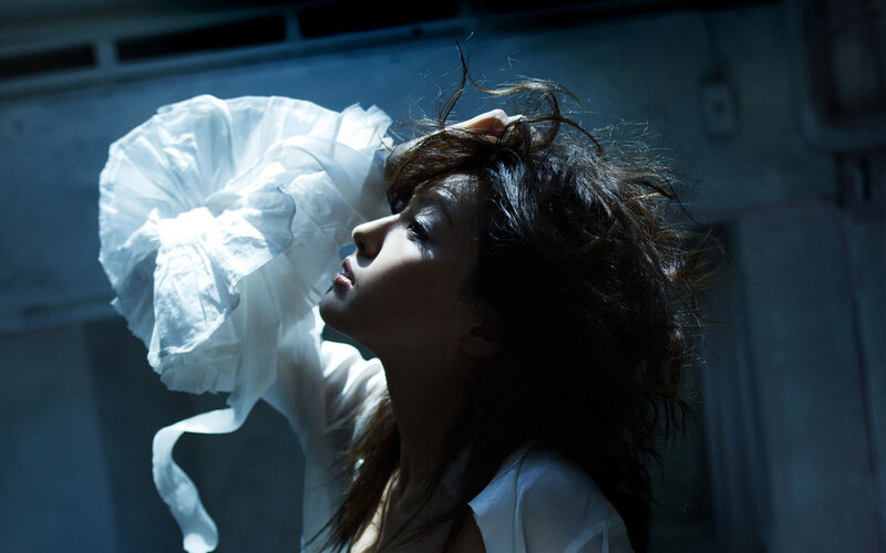 woman with white fabric in dark room