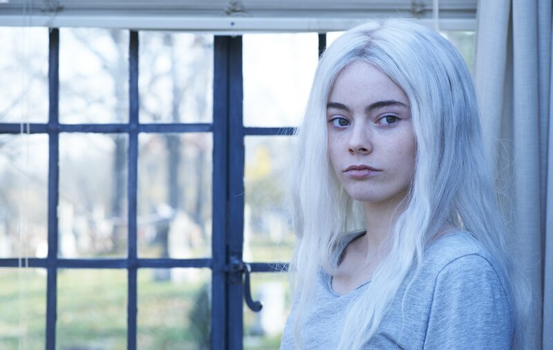woman with white hair by window
