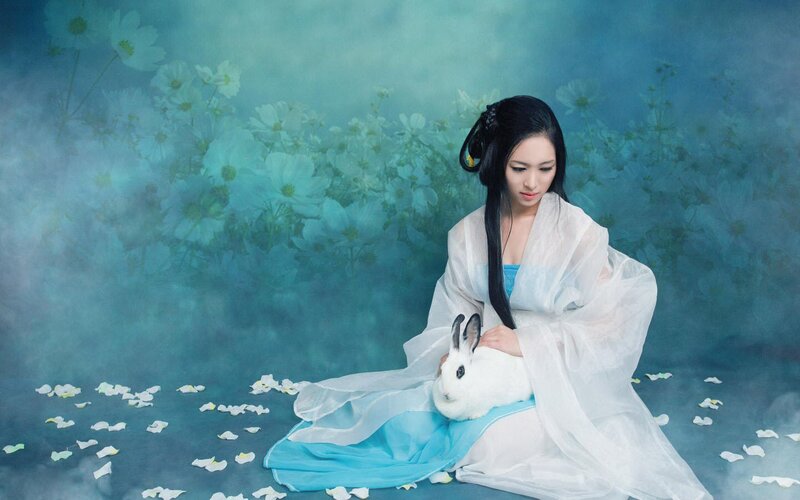 woman with white rabbit in garden