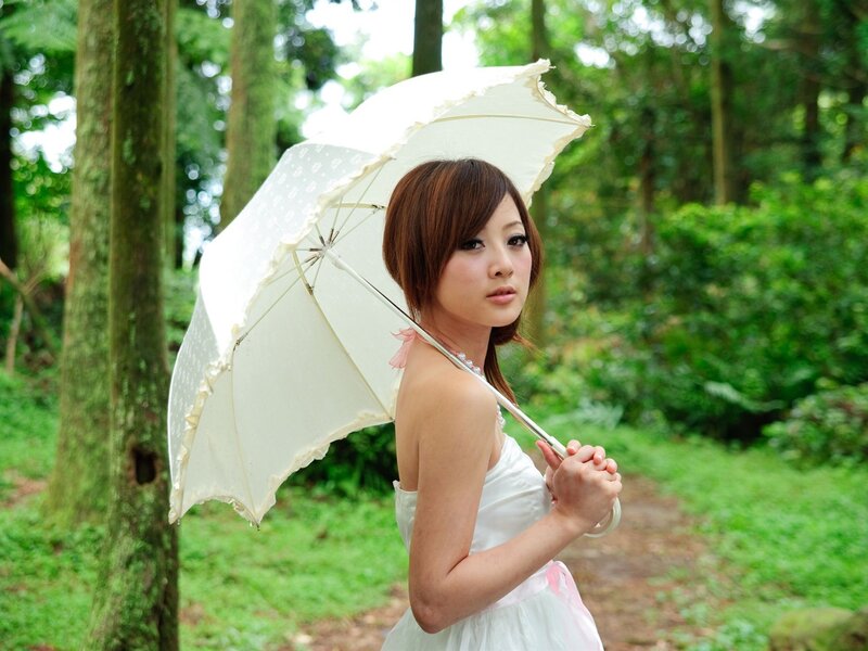 Woman with white umbrella in forest