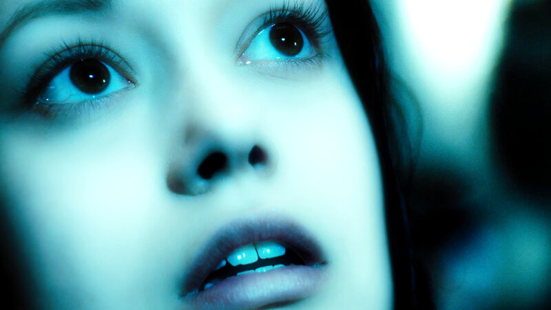 woman with wide eyes in blue light