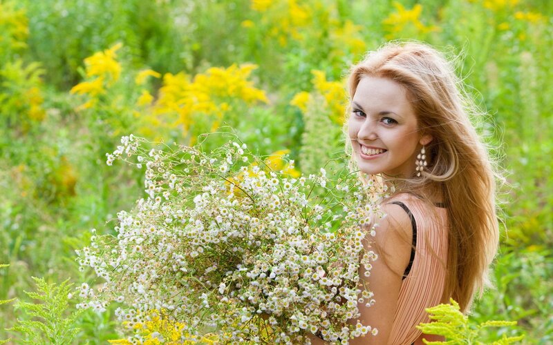 Woman with wildflowers in field