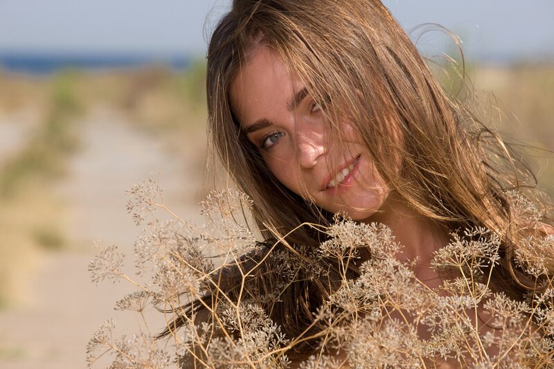 woman with wildflowers on beach