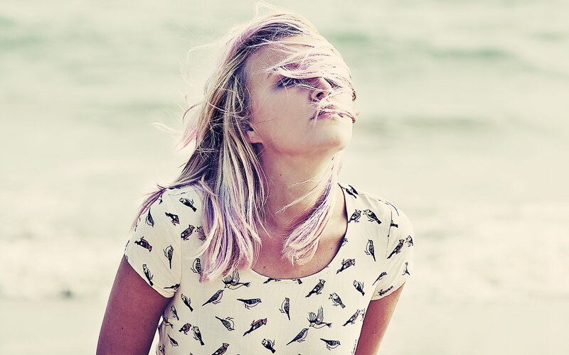 woman with wind-blown hair at beach