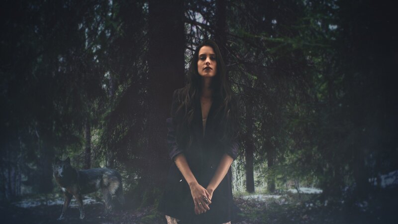 woman with wolf in forest